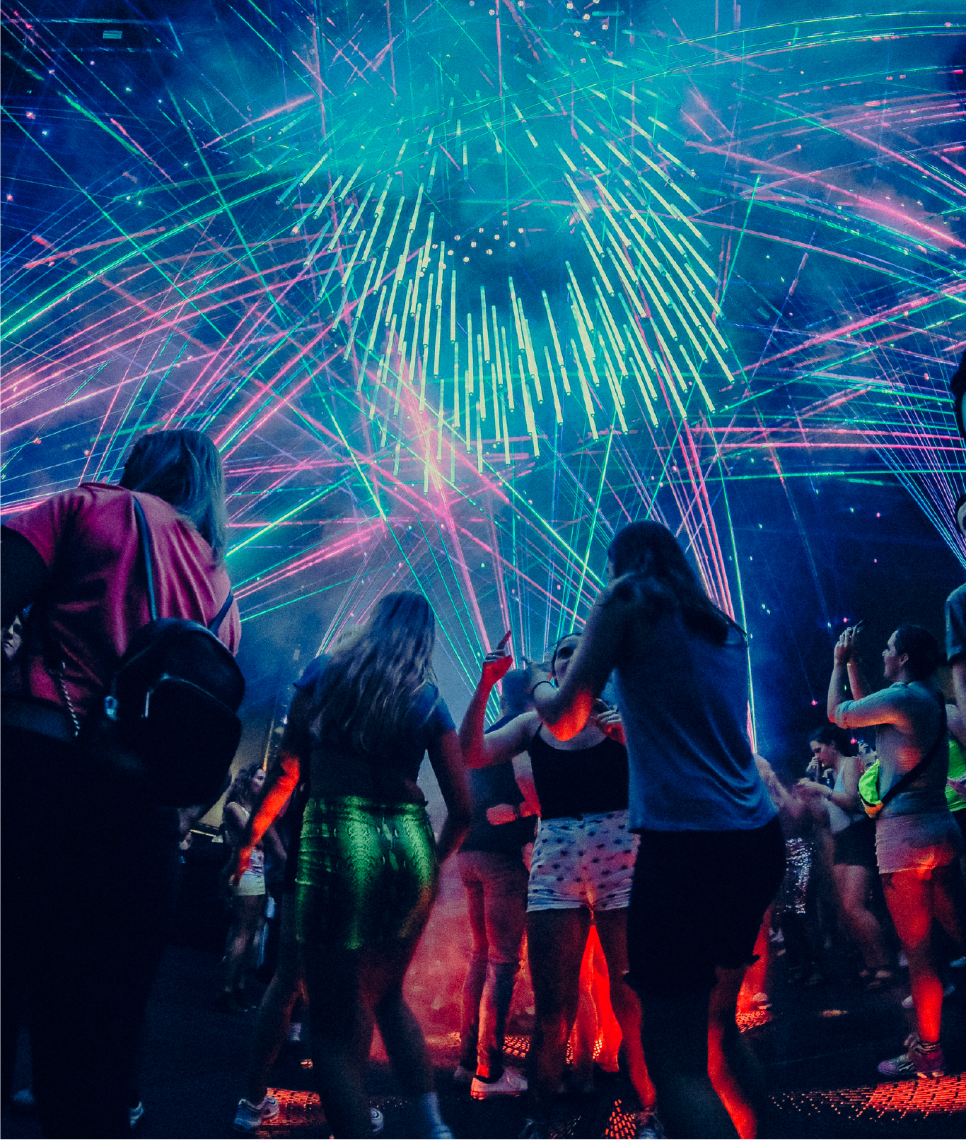 Group of friends dancing under the lasers during Candy World